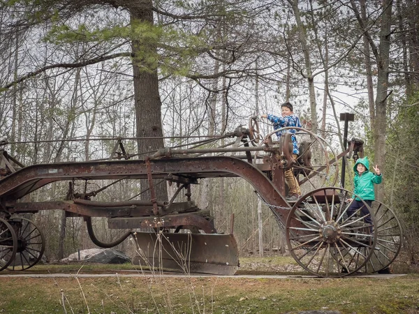 公園で週末を楽しみながら 金属廃車で木に登る遊び心のある白人の兄弟 — ストック写真