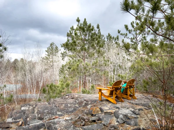 Kaya Oluşumlarının Üzerinde Sarı Sandalyede Oturan Beyaz Çocuk Ormanda Bulutlu — Stok fotoğraf