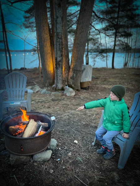 Beyaz Çocuk Gün Batımında Ormanda Adirondack Sandalyesinde Otururken Kamp Ateşinde — Stok fotoğraf