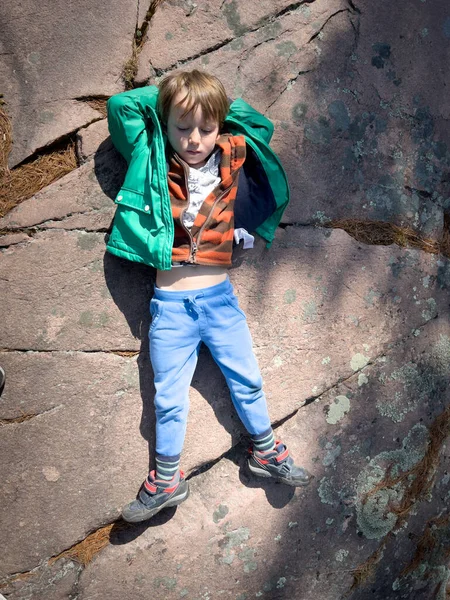 Высокий Угол Обзора Милого Вдумчивого Мальчика Руками Головой Лежащими Скале — стоковое фото