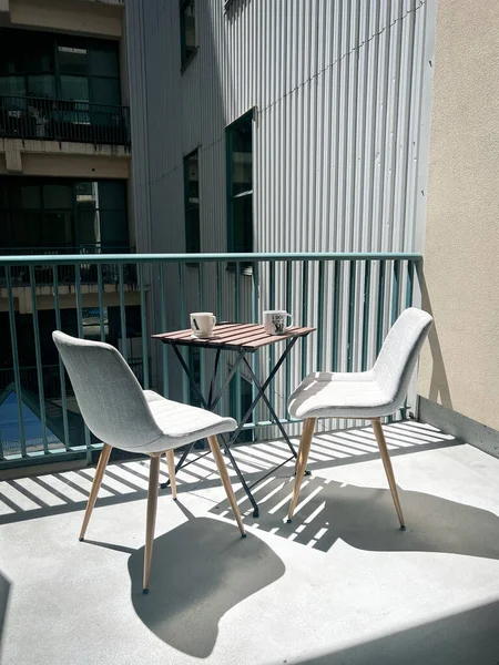 阳光明媚的日子 在阳台上放上一张空椅子的扶手 把咖啡杯放在桌上 — 图库照片