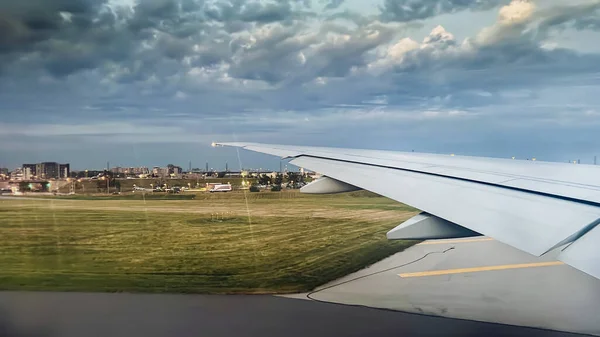 从机场窗口看到的背景是多云天空的飞机机翼图像 — 图库照片