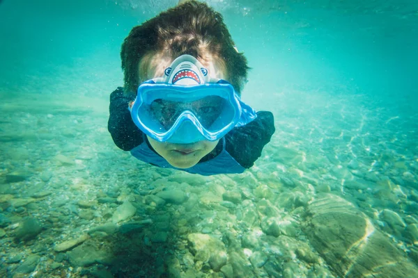 穿着蓝色泳镜的无忧无虑男孩在水下潜水探险的肖像 — 图库照片