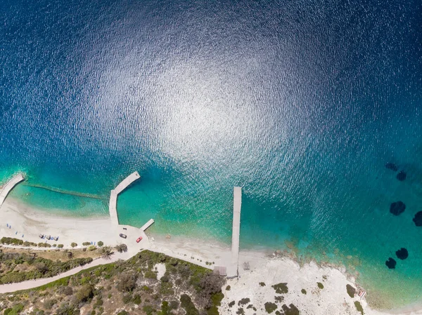 海岸線での桟橋の空中撮影と晴れた日の間の波打つ青い海の景色 ロイヤリティフリーのストック画像