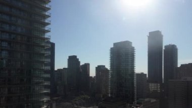 Güneşli bir günde mavi bulutlu gökyüzüne karşı modern yüksek binalar