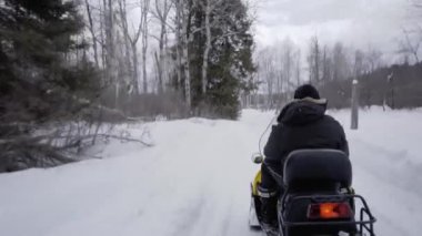 Ontario 'da kışın kar arabası süren bir adam. 