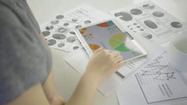 Asyalı kadın mutfaktaki masada dijital tablet kullanıyor.