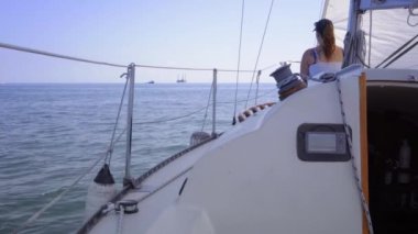 Yat kalkıyor ve kadın gökyüzüne karşı denizde.