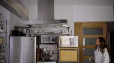 Beyaz bornozlu beyaz kadın modern mutfakta elmalı.