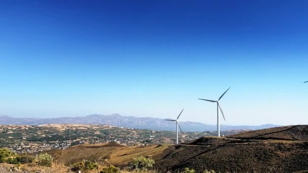 青い空を背景に山の上を風力発電機が回転する風景の美しい景色 — ストック動画