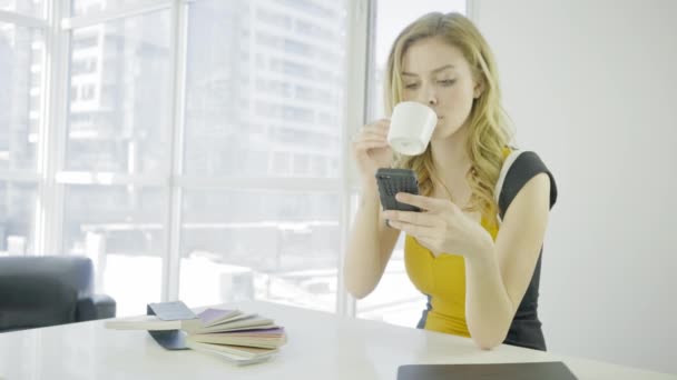 Junge Blonde Frau Benutzt Handy Und Trinkt Kaffee — Stockvideo