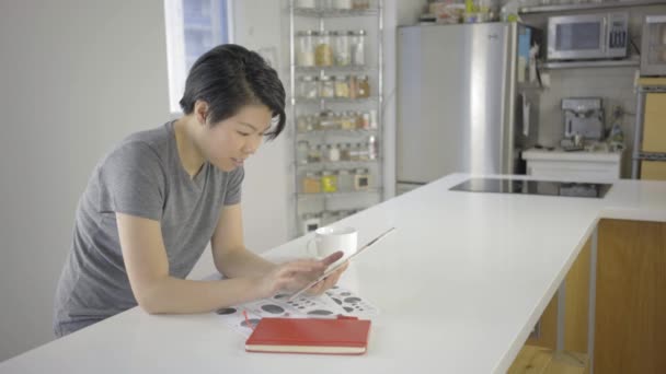Азиатка Помощью Цифрового Планшета Документами Столе Кухне — стоковое видео
