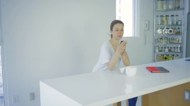 Kvinna Med Smartphone Modernt Kök Vid Bordet — Stockvideo
