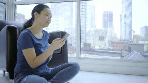幸せなアジアの女性が自宅でスマートフォンを使って — ストック動画