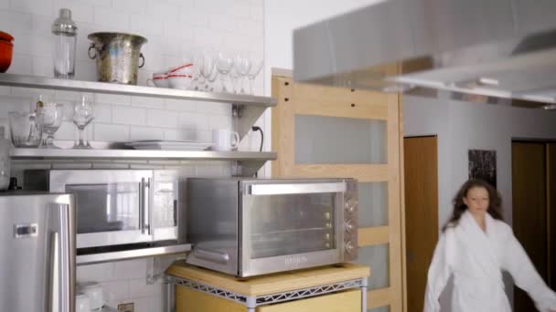 現代の台所の白いバスローブに身を包んだ白人女性 — ストック動画