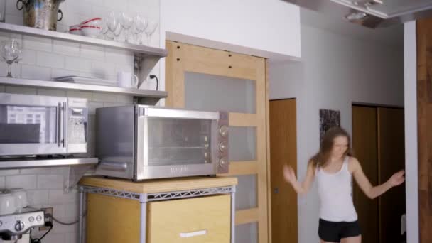 在冰箱旁边的现代厨房里跳舞的高加索女人 — 图库视频影像