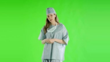 Beyaz kadın doktor yeşil ekranda konuşuyor.