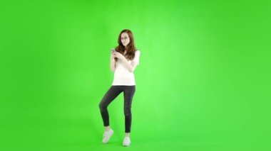 Stüdyo yeşil ekrana karşı akıllı telefonlu beyaz kadın. 