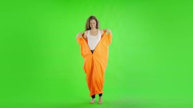 Beyaz kadın yeşil ekrana karşı suçlu tulumu giyiyor. 