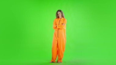 Beyaz kadın yeşil ekrana karşı suçlu tulumu giyiyor. 