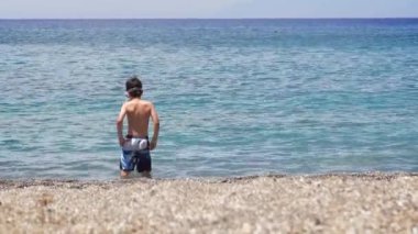 boy is walking on the beach