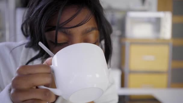 Расстроенная Задумчивая Женщина Белом Халате Пьет Кофе Кухне — стоковое видео
