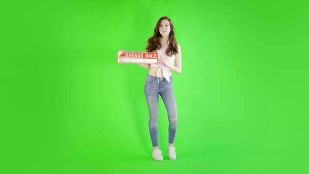 Kaukaska Kobieta Noszenie Casual Dżinsy Trzymając Znak Sprzedaży Przeciwko Studio — Wideo stockowe