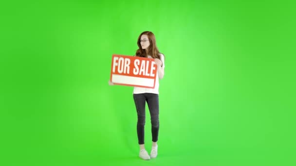Kaukaska Kobieta Noszenie Casual Dżinsy Trzymając Znak Sprzedaży Przeciwko Studio — Wideo stockowe