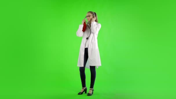 Kaukaska Kobieta Nosić Labcoat Trzymając Serce Zabawka Przeciw Zielony Ekran — Wideo stockowe