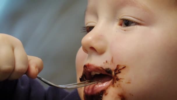 小さな男の子食べるチョコレートとともにフォークで家 — ストック動画