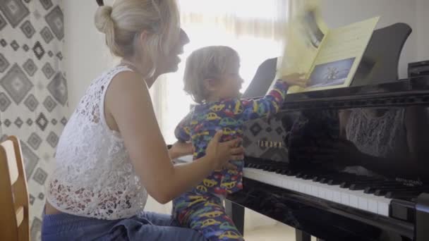 Γιος Κάθεται Στην Αγκαλιά Της Μητέρας Παίζει Πιάνο — Αρχείο Βίντεο