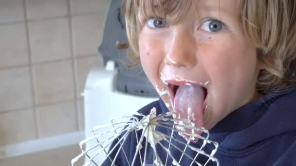 Nahaufnahme Von Junge Lecken Schlagsahne Aus Draht Besen Küche — Stockvideo
