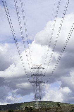 Bulutlu gökyüzünün arka planına karşı güç direkleri ve yüksek gerilim hatları, elektrik hatları.