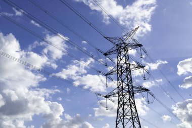 Bulutlu gökyüzünün arka planına karşı güç direkleri ve yüksek gerilim hatları, elektrik hatları.