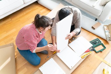 Genç bir çift evlerinde mobilya montajı yaparak evlendi. Elinde tornavida ve kullanma kılavuzunu takip edecek aletlerle. Becerikli çift. Sahibi onlar. Yeni ev, yeni mobilyalar.