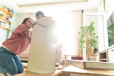 Genç bir çift evlerinde mobilya montajı yaparak evlendi. Elinde tornavida ve kullanma kılavuzunu takip edecek aletlerle. Becerikli çift. Sahibi onlar. Yeni ev, yeni mobilyalar.