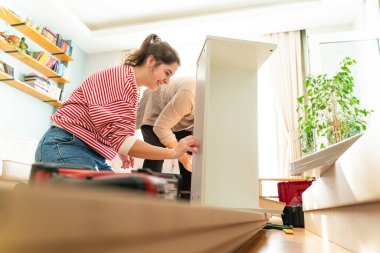 Genç bir çift evlerinde mobilya montajı yaparak evlendi. Elinde tornavida ve kullanma kılavuzunu takip edecek aletlerle. Becerikli çift. Sahibi onlar. Yeni ev, yeni mobilyalar.
