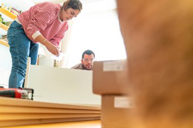 Genç bir çift evlerinde mobilya montajı yaparak evlendi. Elinde tornavida ve kullanma kılavuzunu takip edecek aletlerle. Becerikli çift. Sahibi onlar. Yeni ev, yeni mobilyalar.