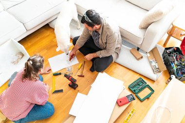 Genç bir çift evlerinde mobilya montajı yaparak evlendi. Elinde tornavida ve kullanma kılavuzunu takip edecek aletlerle. Becerikli çift. Sahibi onlar. Yeni ev, yeni mobilyalar.