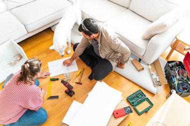 Genç bir çift evlerinde mobilya montajı yaparak evlendi. Elinde tornavida ve kullanma kılavuzunu takip edecek aletlerle. Becerikli çift. Sahibi onlar. Yeni ev, yeni mobilyalar.