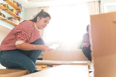Genç bir çift evlerinde mobilya montajı yaparak evlendi. Elinde tornavida ve kullanma kılavuzunu takip edecek aletlerle. Becerikli çift. Sahibi onlar. Yeni ev, yeni mobilyalar.