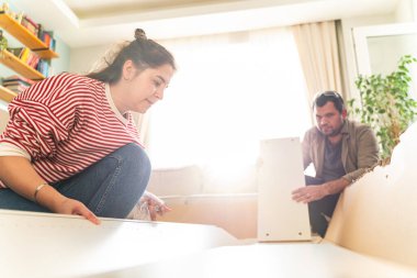 Genç bir çift evlerinde mobilya montajı yaparak evlendi. Elinde tornavida ve kullanma kılavuzunu takip edecek aletlerle. Becerikli çift. Sahibi onlar. Yeni ev, yeni mobilyalar.