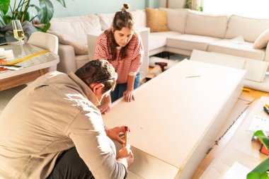 Genç bir çift evlerinde mobilya montajı yaparak evlendi. Elinde tornavida ve kullanma kılavuzunu takip edecek aletlerle. Becerikli çift. Sahibi onlar. Yeni ev, yeni mobilyalar.