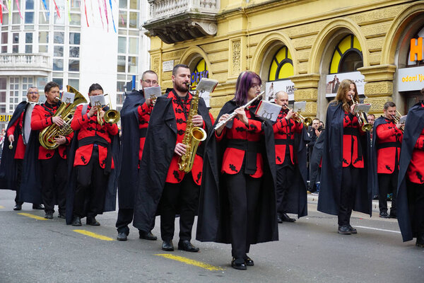 Rijeka, Croatia, 19th February, 2023. Brass band in red and black costumes concerted at the festival parade