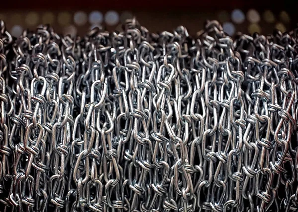 Metal chains on the twisted reel in silver color vertical background close up view