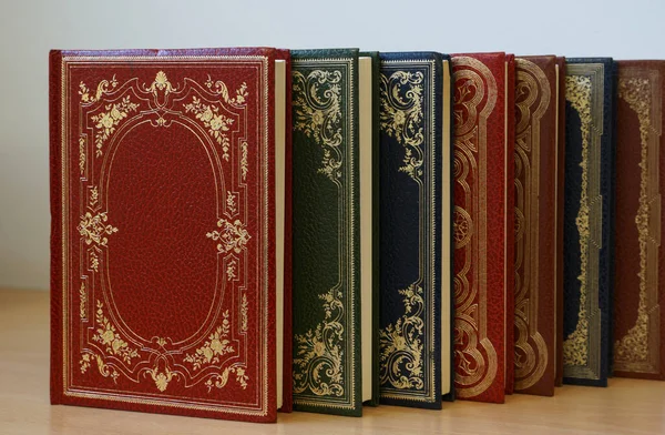 Series of rare vintage colorful books bound in leather lined on the bookshelf