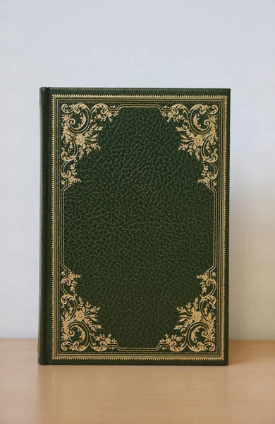 绿色皮革封皮上印有金色卷须装饰细节的旧书 — 图库照片