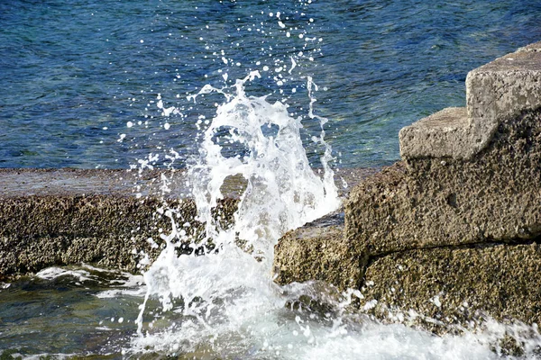 ビーチの海に石の階段を飛ばす大きな白い波 — ストック写真