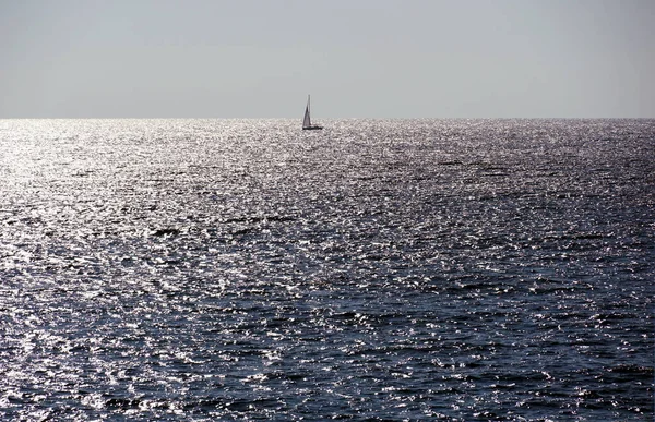 ヨットや銀輝く波の表面をセーリングと光沢のある海の地平線 — ストック写真