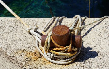 Kayıkları bağlamak için taş iskeledeki paslı metalin kordonu ve paslı teli.